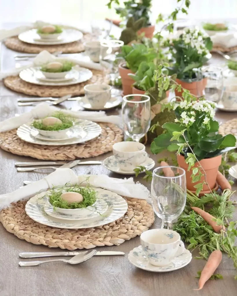 Easter table setting with lots go greenery and little nests on plates