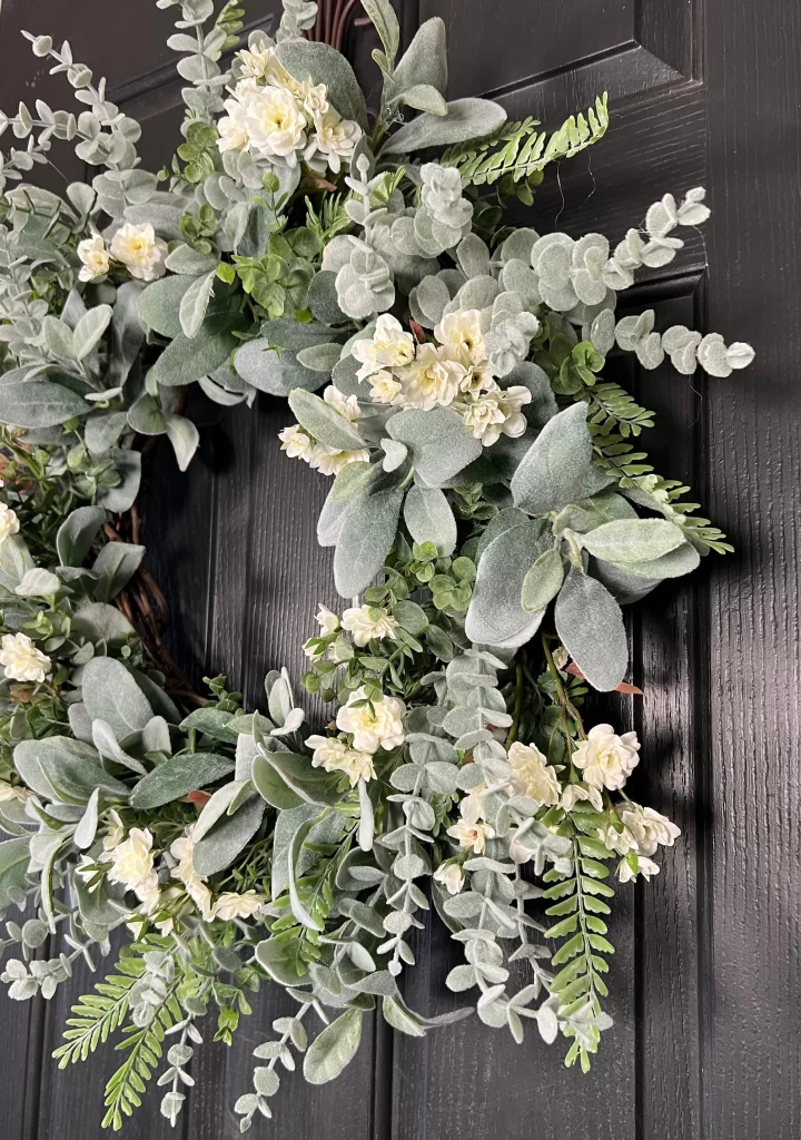 A mix of greenery and blooms wreath on front door