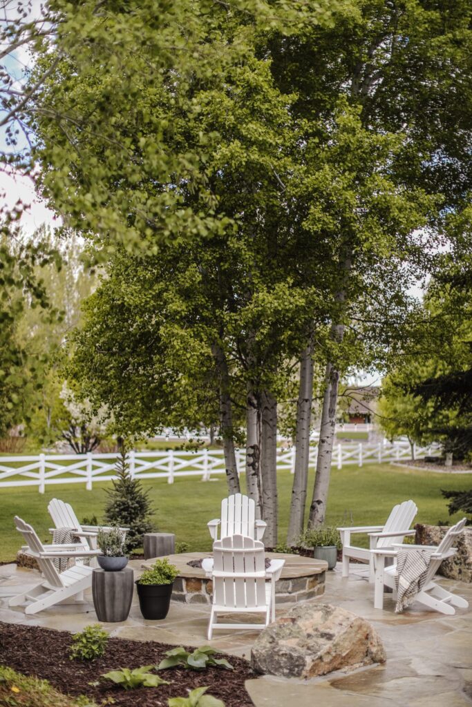 Flagstone fire pit design with white chairs